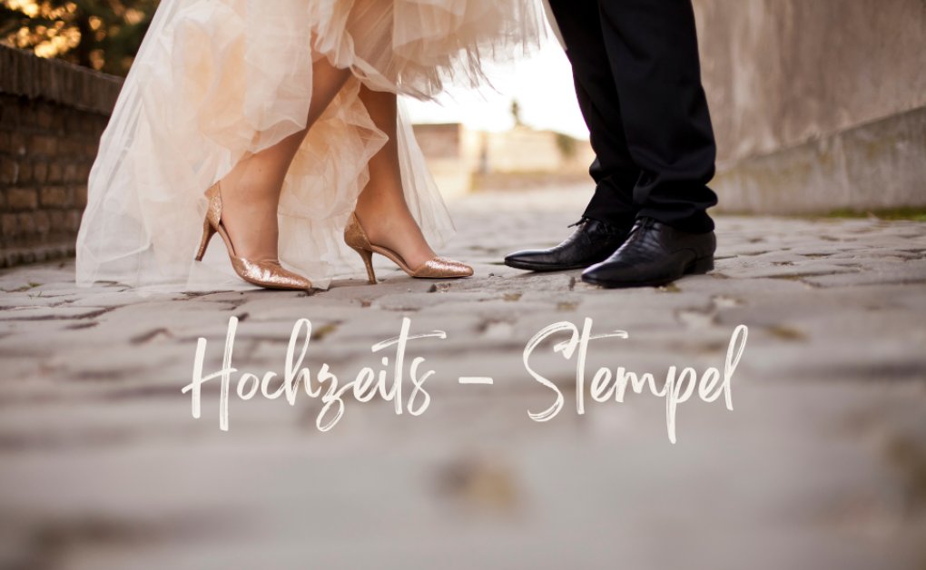 Detailaufnahme von Brautkleid und Anzugschuhen auf Kopfsteinpflaster mit Schriftzug Hochzeits-Stempel