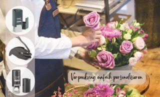 Floristin arrangiert rosa und lila Rosen neben Trodat Stempeln für personalisierte Verpackungen